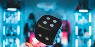 person's left palm about to catch black dice