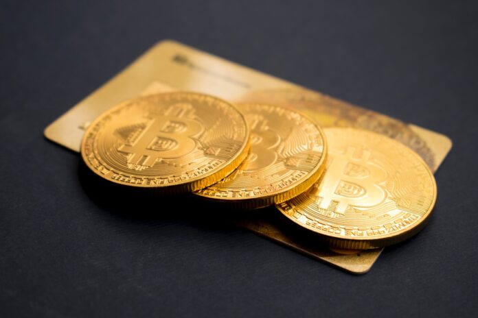 Photo by Dmitry Demidko three round gold-colored Bitcoin tokens