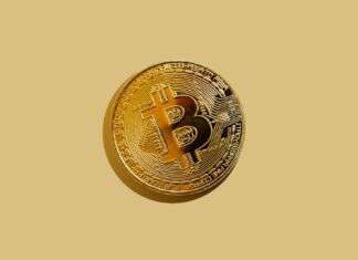gold round coin on white surface