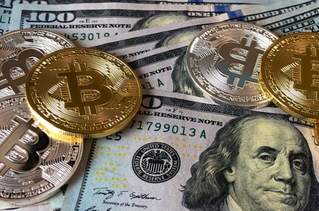 Photo by David McBee Bitcoins and U.s Dollar Bills