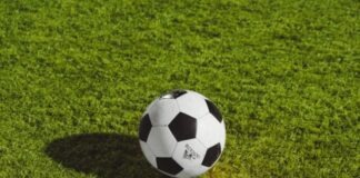 white and black soccer ball on grass field