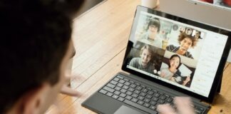person in blue long sleeve shirt using black Surface