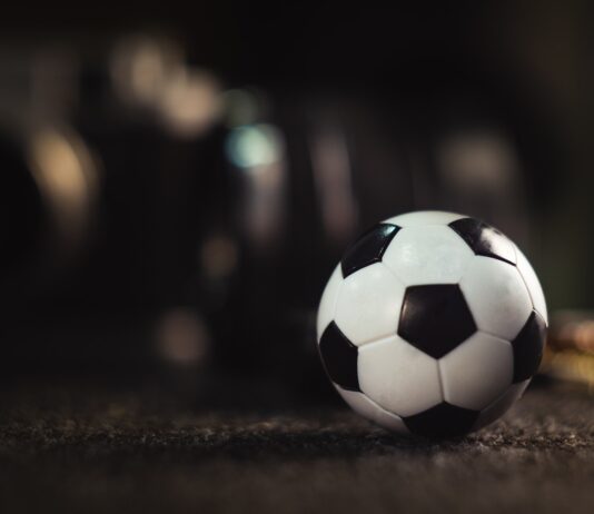 white and black soccer ball on black sand