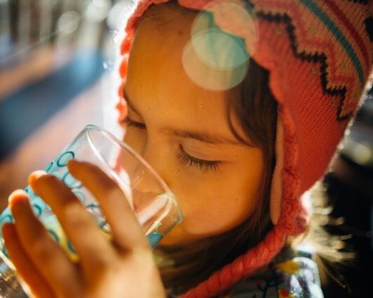selective focus photography of girl drinking water