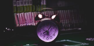 silver twin bell alarm clock on green table