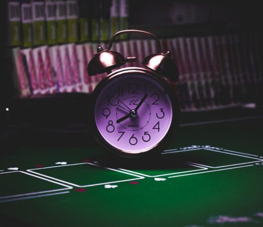 silver twin bell alarm clock on green table