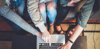 three person pointing the silver laptop computer
