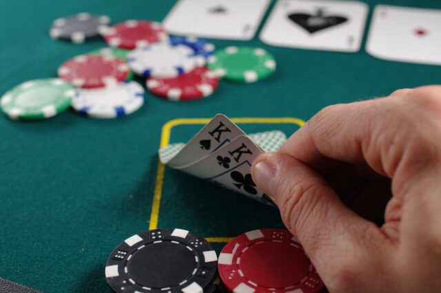 Photo by Michał Parzuchowski person holding white and black playing cards