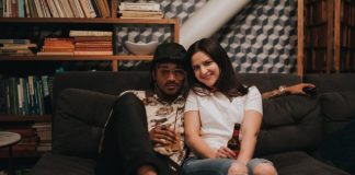 woman in white crew neck t-shirt sitting on black couch