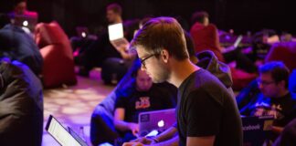 man using laptop in front of brown chair