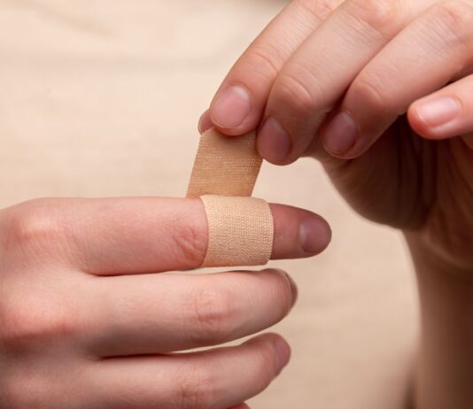 person with band aid on middle finger