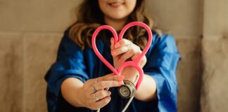 girl in blue jacket holding red and silver ring