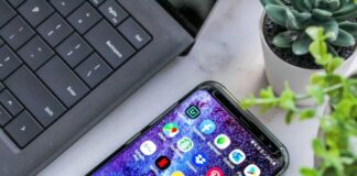 smartphone turned on beside laptop