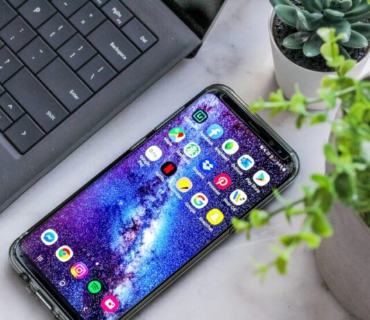 smartphone turned on beside laptop