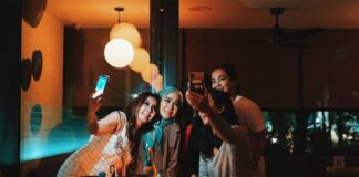 3 women smiling and standing near table