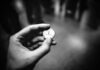grayscale photography of person holding coin