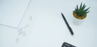 black calculator beside black pen on white printer paper