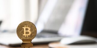 round gold-colored bitcoin on table