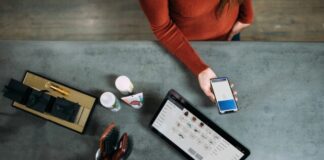 person holding smartphone beside tablet computer