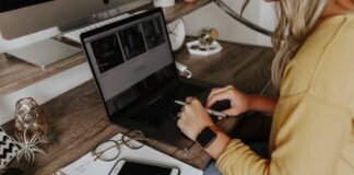 person in blue denim jeans using macbook pro