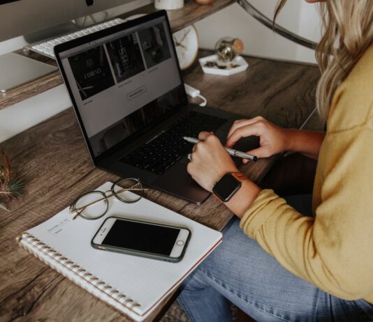 person in blue denim jeans using macbook pro