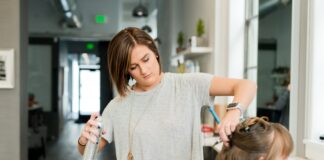 woman wearing gray top holding gray spray bottle