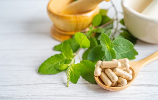 Alternative medicine herbal organic capsule drug with herbs leaf