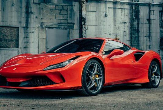 red ferrari 458 italia parked near gray building