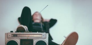 woman laying on bed near gray radio