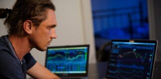 man sitting in front of the MacBook Pro