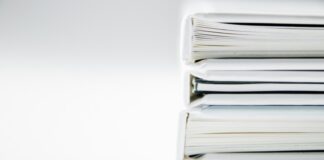 A stack of thick folders on a white surface