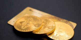 three round gold-colored Bitcoin tokens