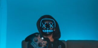 person sitting on chair while holding Xbox One controller