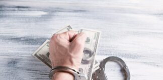 person holding silver ring on 100 us dollar bill