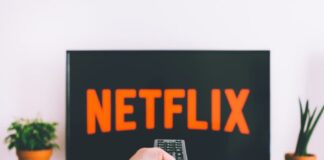 person holding remote pointing at TV