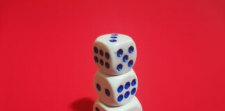 two dices stacked on top of each other on a red surface