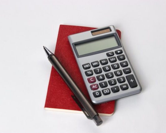 black and silver calculator beside black pen