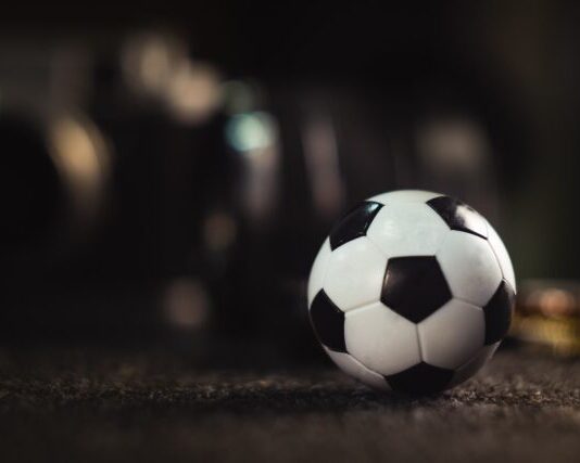 white and black soccer ball on black sand