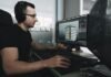 man in black tank top wearing black sunglasses using computer