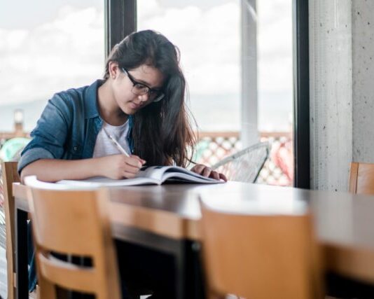 woman writing on book