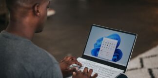 man in gray long sleeve shirt using Windows 11 computer