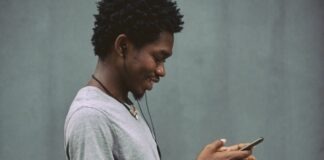 man in white crew neck t-shirt holding smartphone