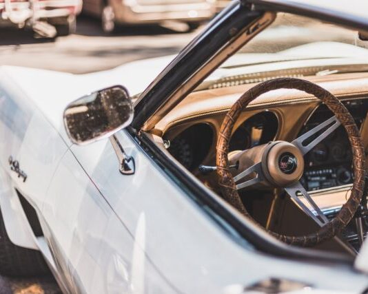 white vehicle parks on road during daytime