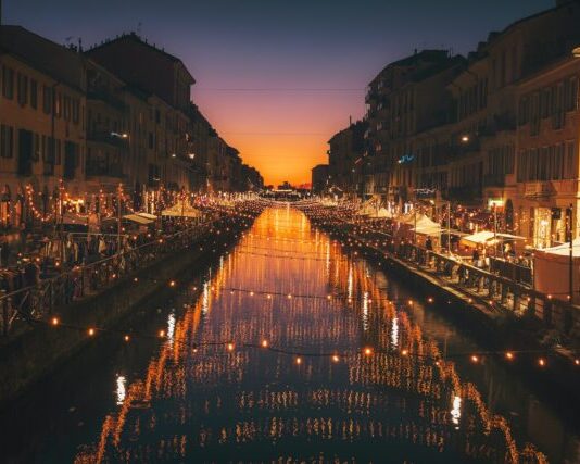 reflective photography of string lights above river