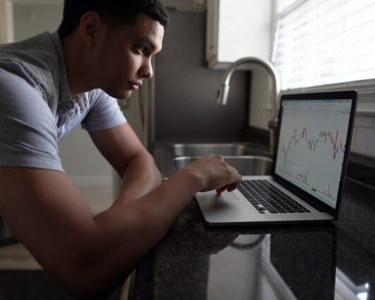 lalaki nga grey t-shirt gamit ang macbook pro