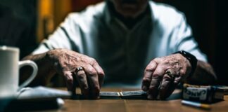 man in white dress shirt using macbook pro on brown wooden table