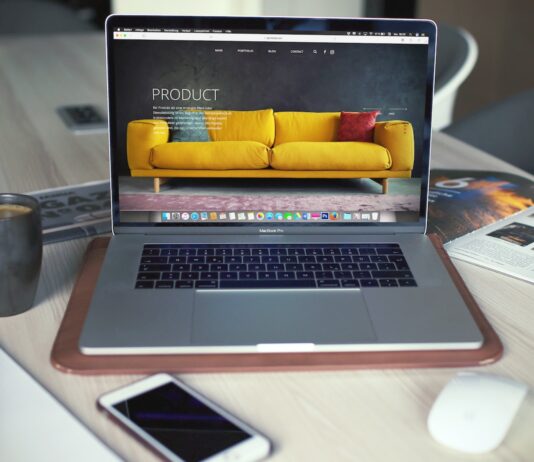 anayatsa MacBook Pro pafupi ndi imvi makapu