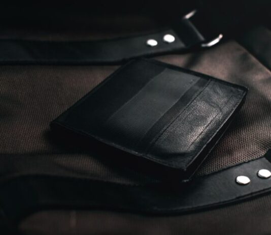 black leather bifold wallet on brown textile