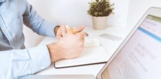 person writing on white notebook