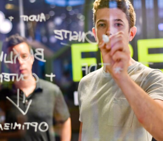 man writing on glass board